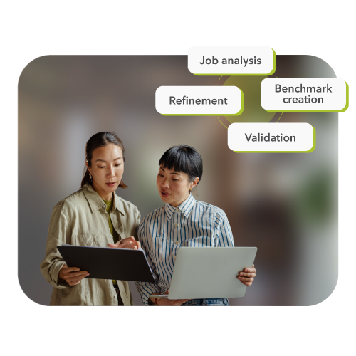 Two people discussing a cycle diagram illustrating the methodology behind pre-employment assessments.